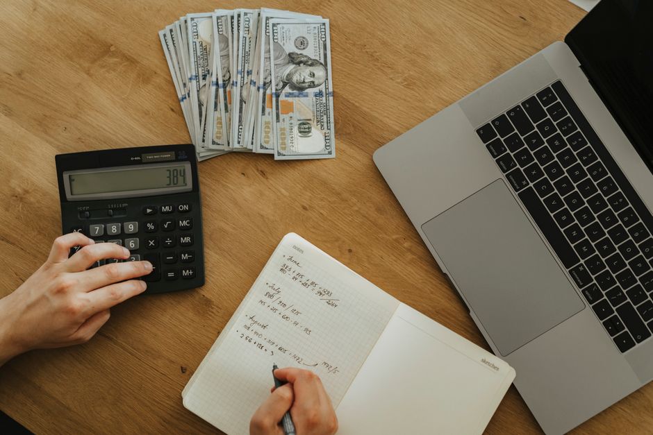 Persona usando una calculadora para simular la rentabilidad de un depósito
