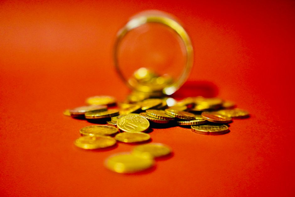 Monedas doradas apiladas sobre fondo rojo, simbolizando el ahorro en depósitos a plazo fijo