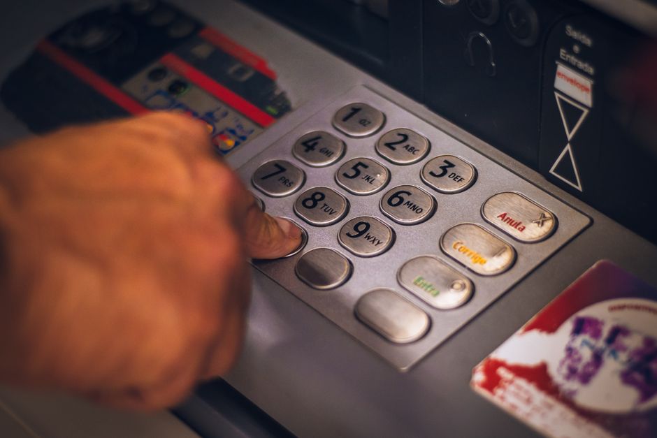 Persona tecleando un IBAN en un cajero para hacer una operación bancaria