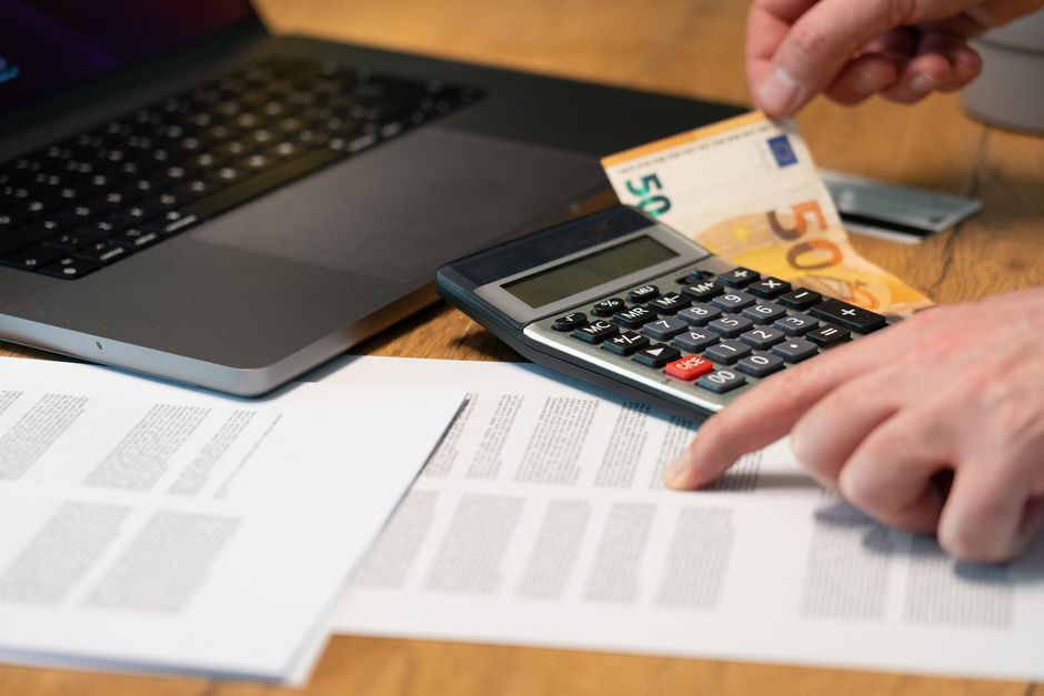 Calculadora, billete de 50 euros y documentos sobre una mesa de trabajo